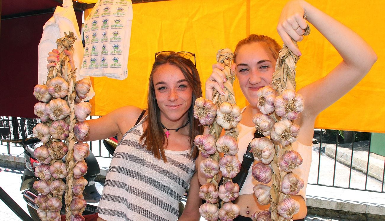 Dos jóvenes, con ristras de ajos, durante la tradicional feria.