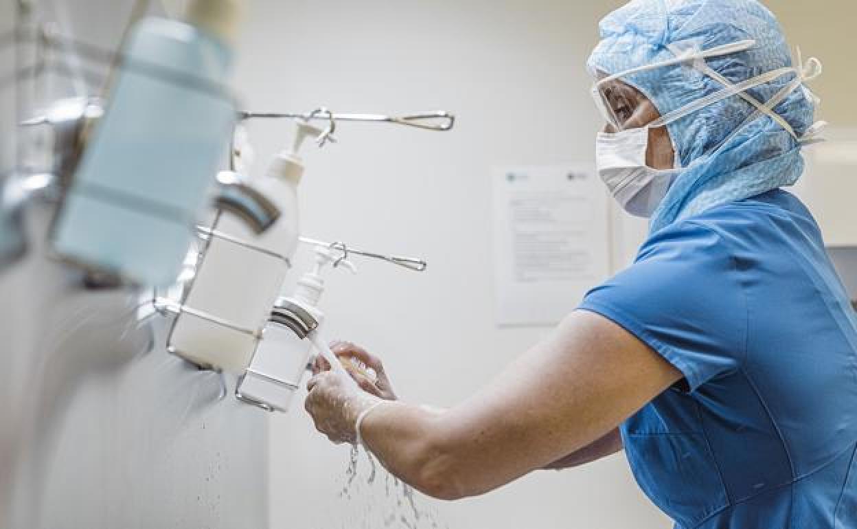 Imagen de una médico antes de atender a un paciente. 