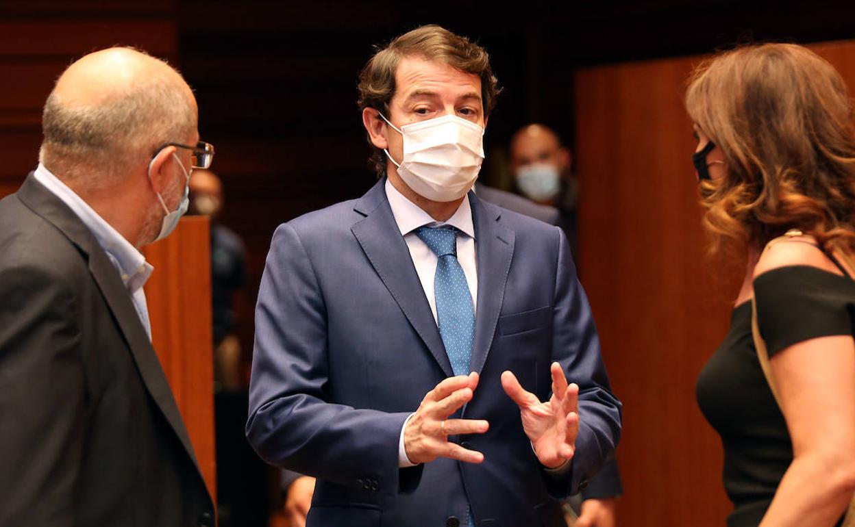 El presidente de la Junta, Alfonso Fernández Mañueco, conversa con el vicepresidente, Francisco Igea, y con la consejera de Empleo, Carlota Amigo, durante el Pleno en las Cortes de Castilla y León.