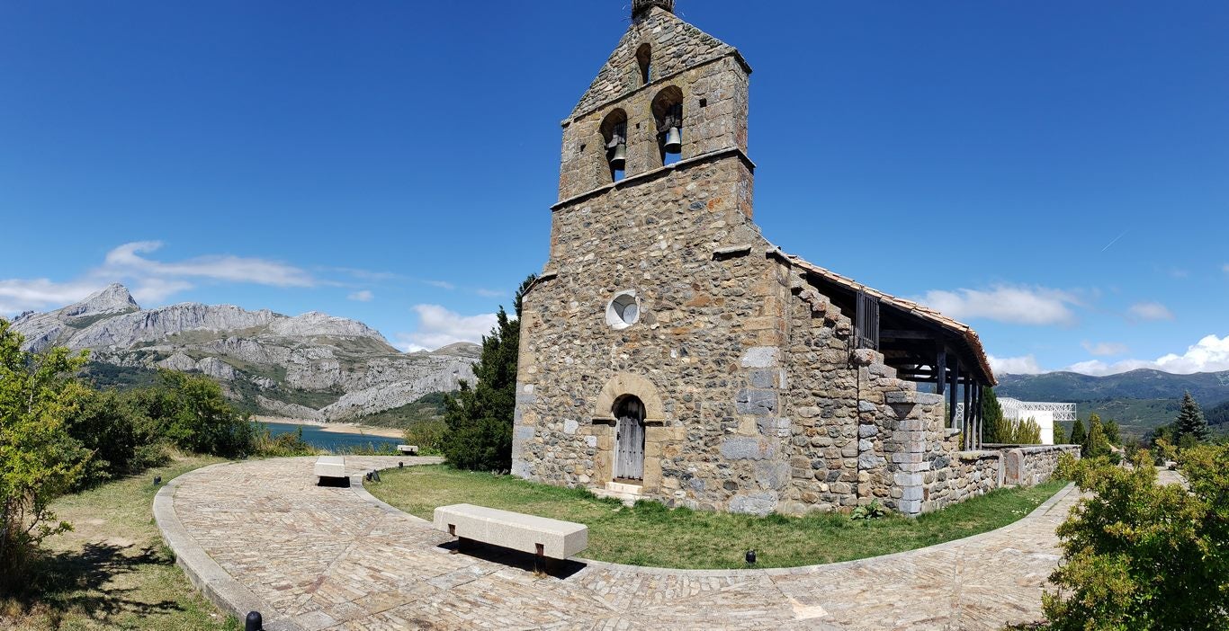 Ubicado junto a la Ermita de Nuestra Señora, en Riaño, el banco ofrece unas privilegiadas vistas sobre el pantano y Picos | El entorno, con las viejas campanas y un 'horreo leonés', completa un escenario idílico. 