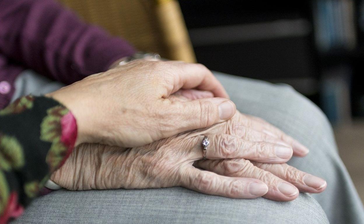 Dos ancianos dándose la mano.