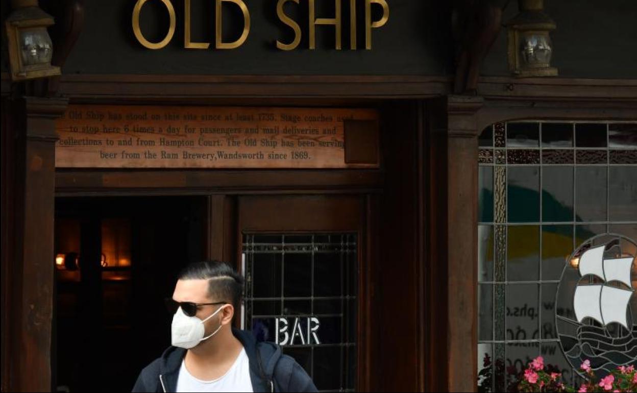 Un hombre en la puerta de un pub de Londres. 