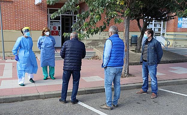 Imagen. Las sanitarias conversan con los vecinos concentrados. 