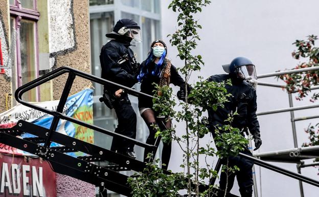 La policía saca a una de los okupas que vivían de un edificio desalojado en Berlín.