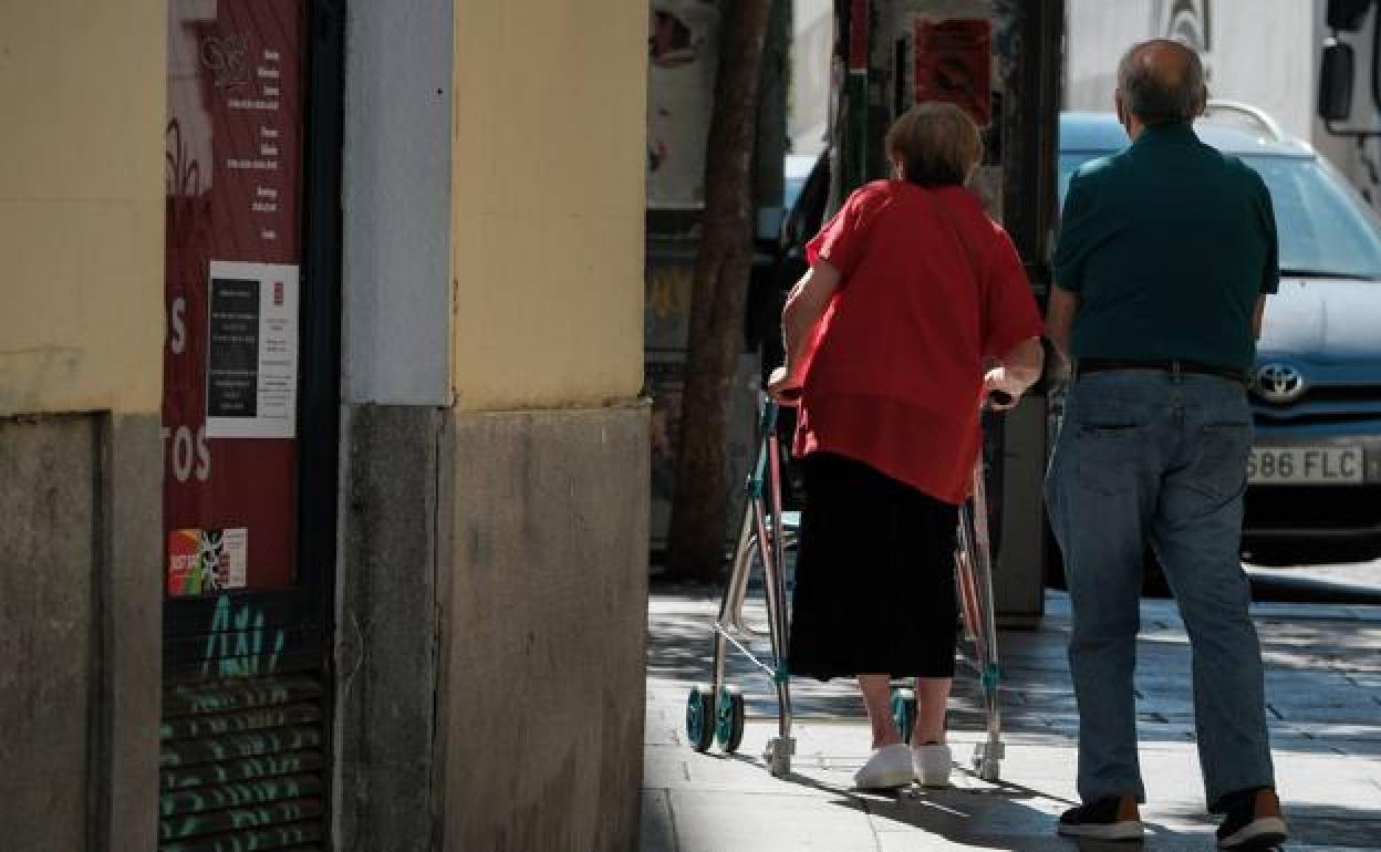 Dos jubilados caminan por la calle. 