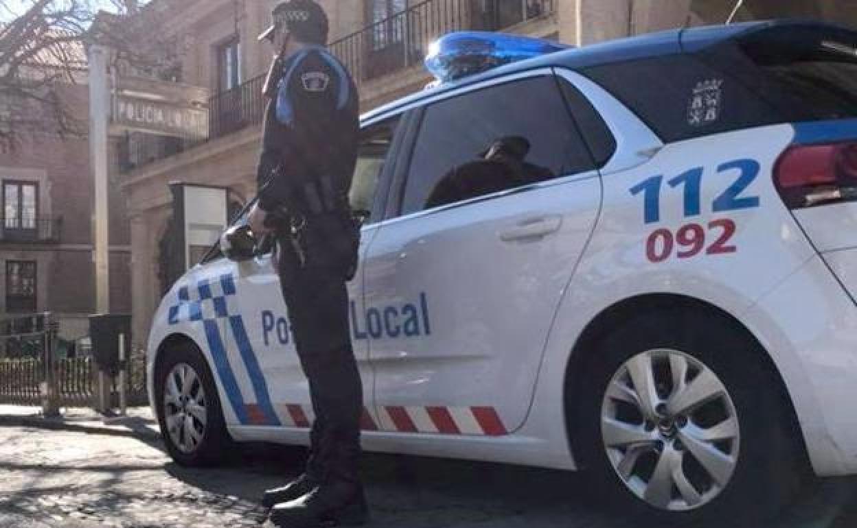 Un coche y un agente de la Policía Local de León. 