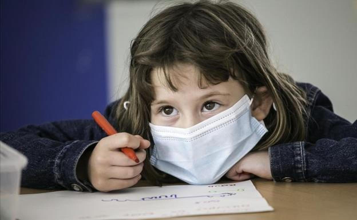 Una niña en una clase de infantil. 