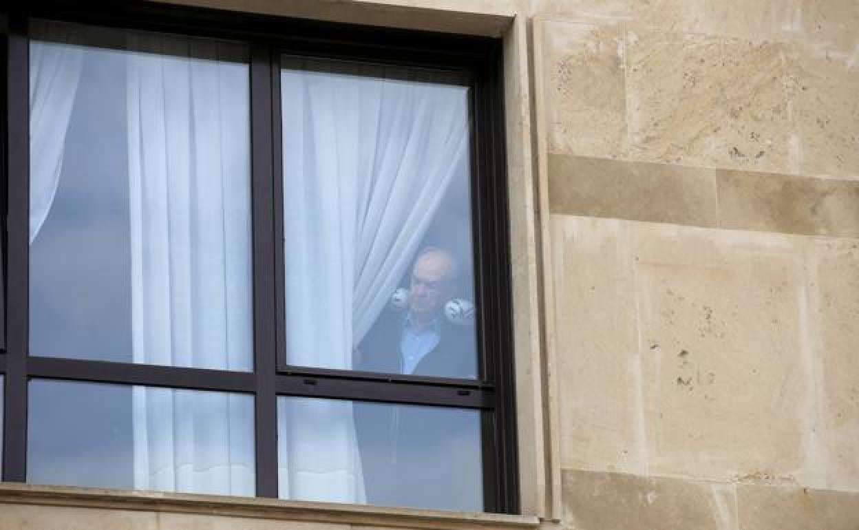 Una persona mira por la ventana en una residencia de ancianos.