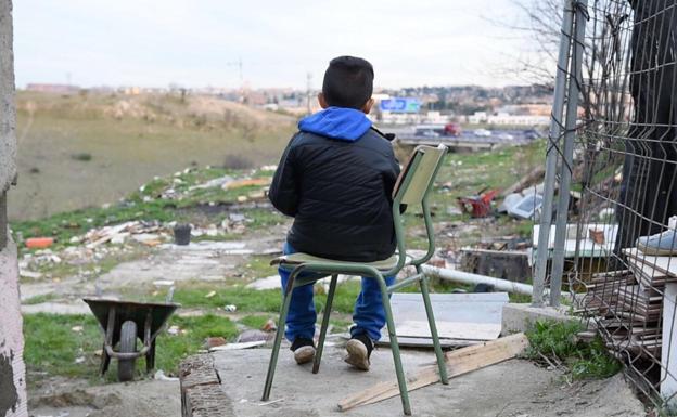 Un niño observa el horizonte desde una barriada marginal. 