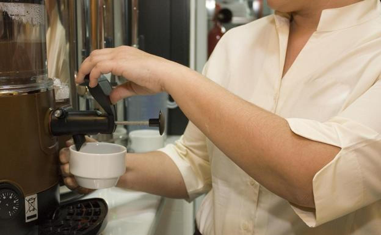 Una camarera sirve café en un bar de León. 