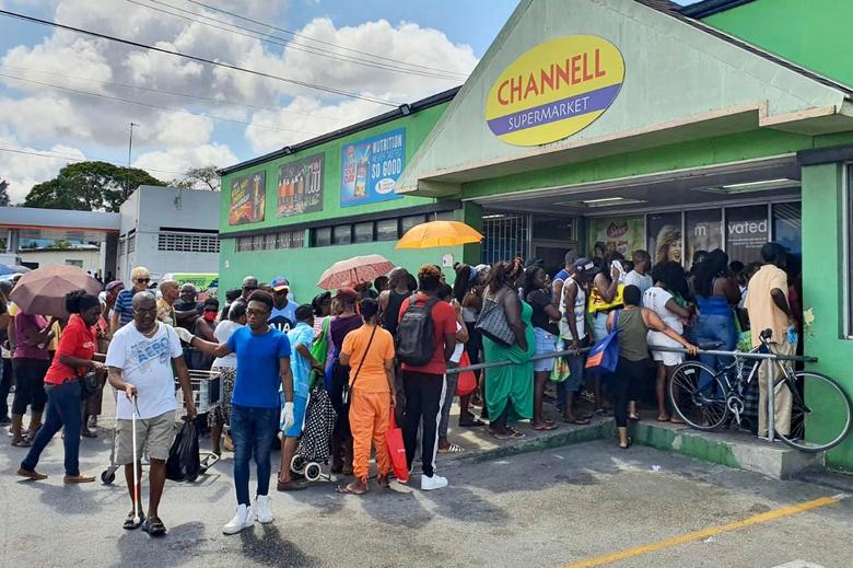 Barbados | Los clientes esperan en la cola de un supermercado antes del toque de queda de 24 horas, que se extiende hasta el 14 de abril, a partir de las 8 pm en St Michael, Barbados, el 3 de abril de 2020. 