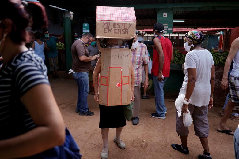 Cuba | La enfermera jubilada Feridia Rojas, de 82 años, usa cartón con forma de casa en un mercado para protegerse de la propagación del coronavirus en La Habana