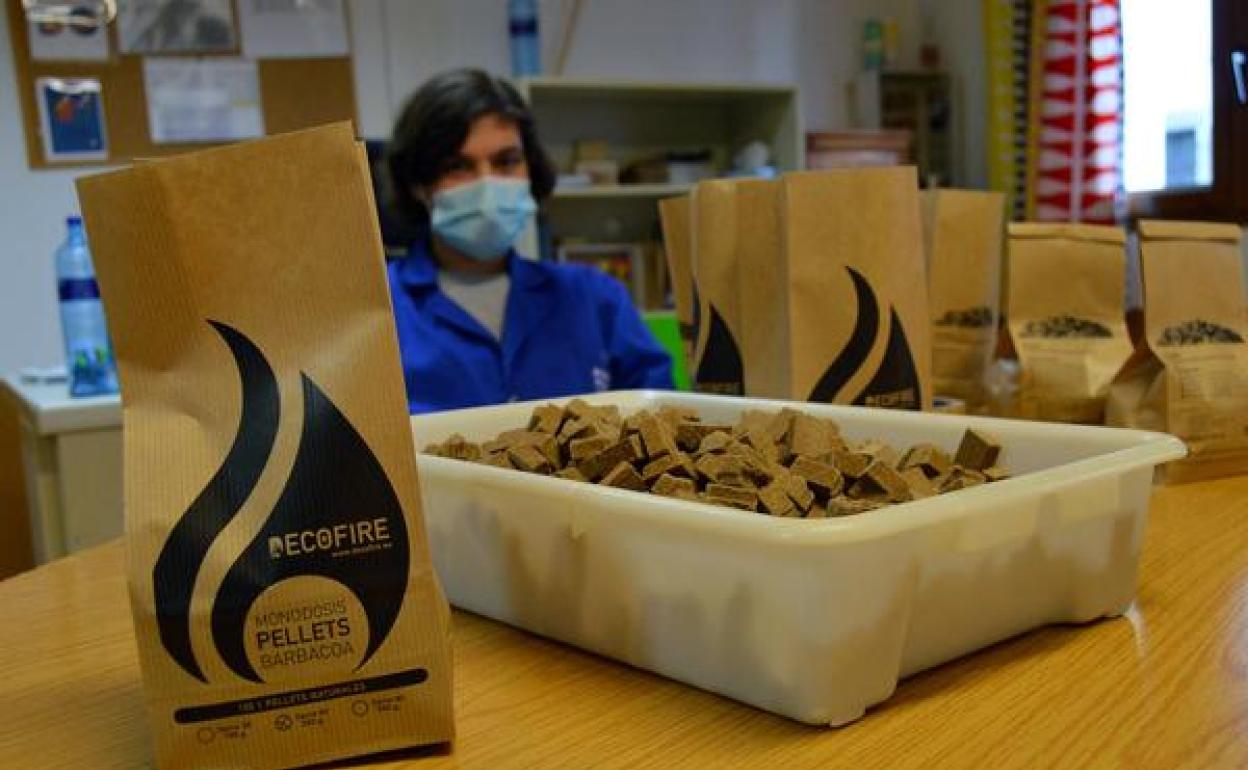 Usuarios de Asprona Bierzo envasan las monodosis de 'pellets' para las barbacoas portátiles de la empresa berciana Decofire.