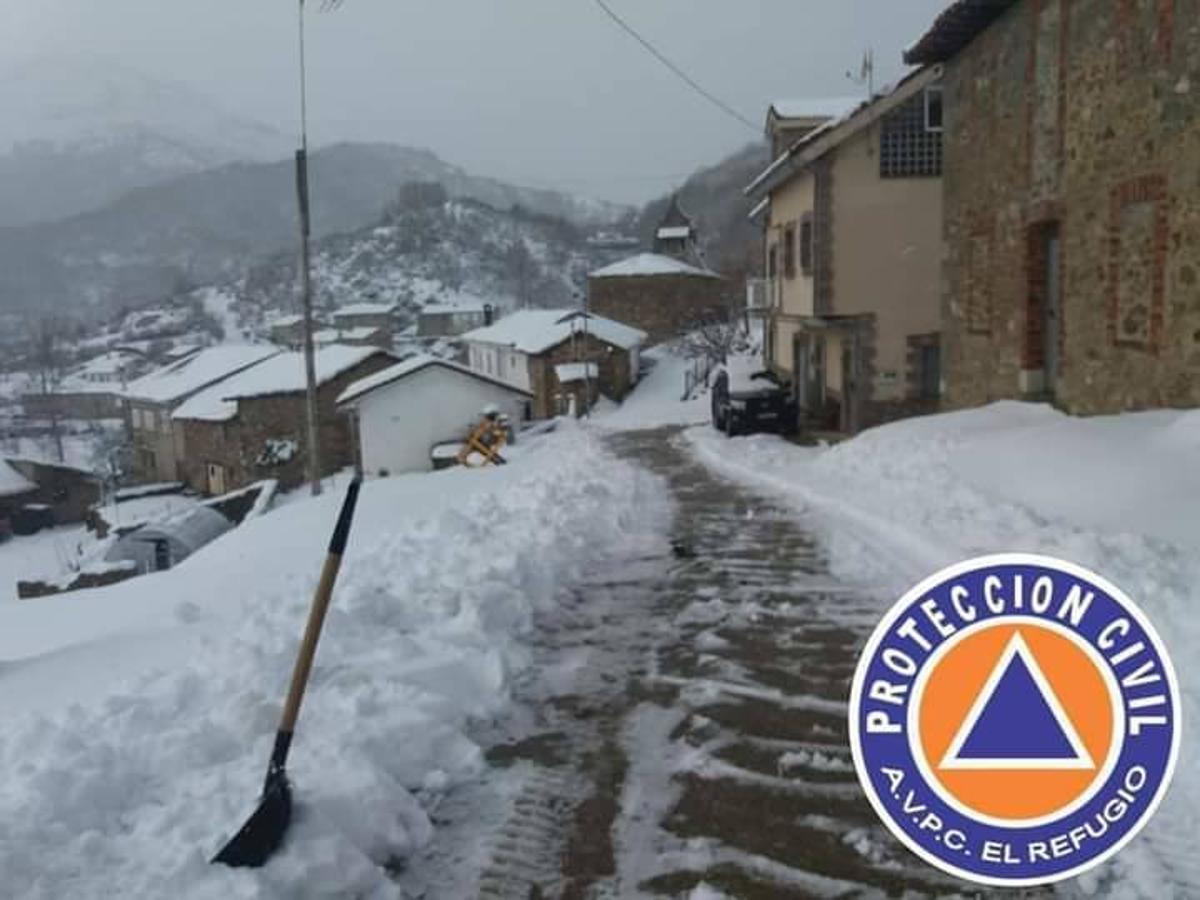 Los voluntarios de Protección Civil despejan la nieve caída en los últimos días en Ferreras del Puerto.