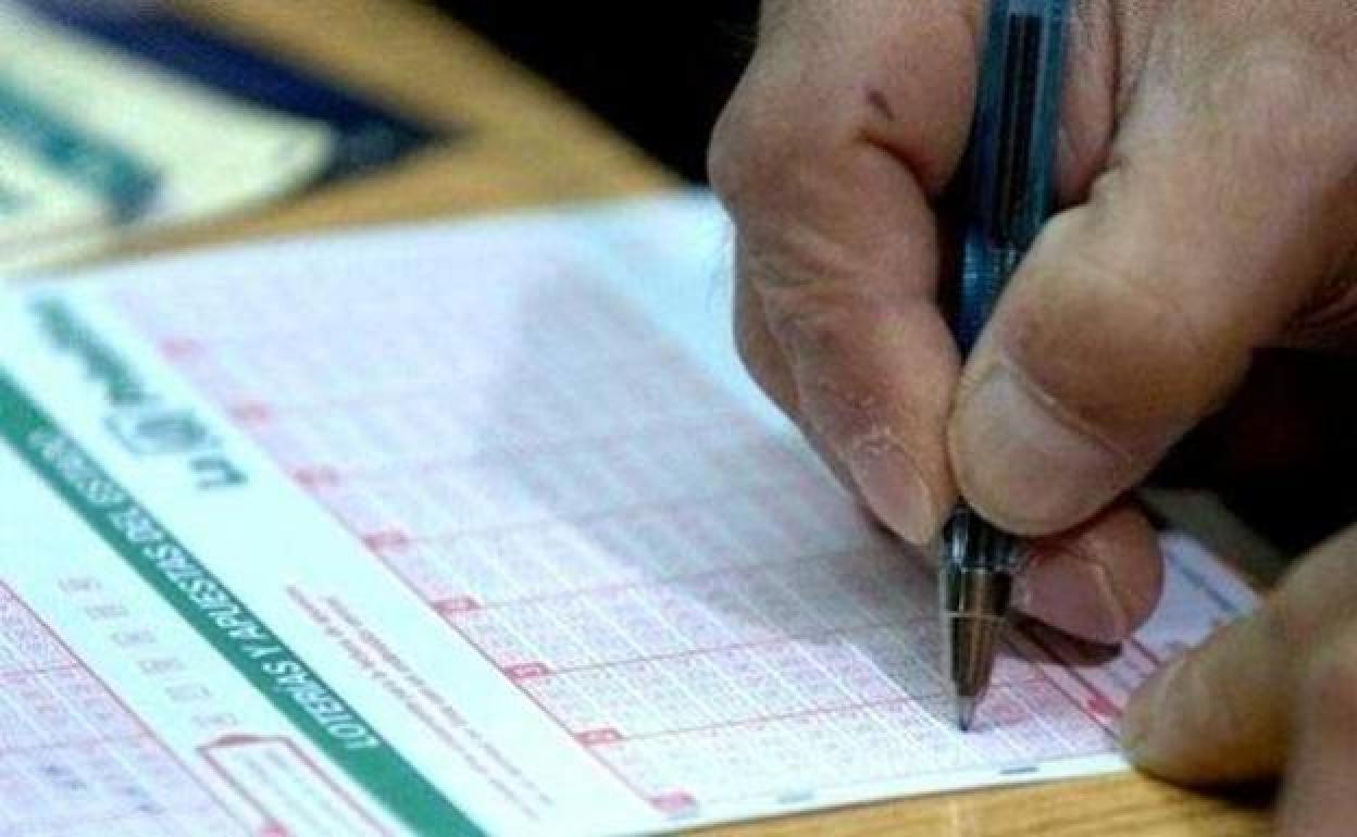 Una persona rellena un boleto de la Bonoloto.