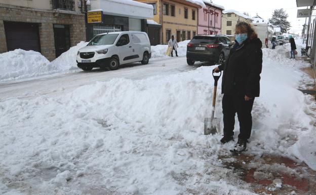 Galería. Una vecina de Villamanín retira nieve de su vivienda, mientras el carnicero reparte por la zona.