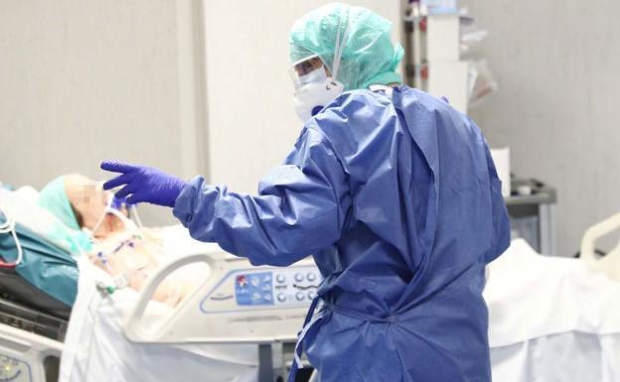 Una enfermera atiende a un paciente con coronavirus en la UCI.