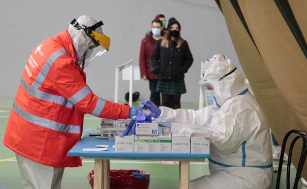 Los sanitarios preparan las muestras mientras las personas esperan.