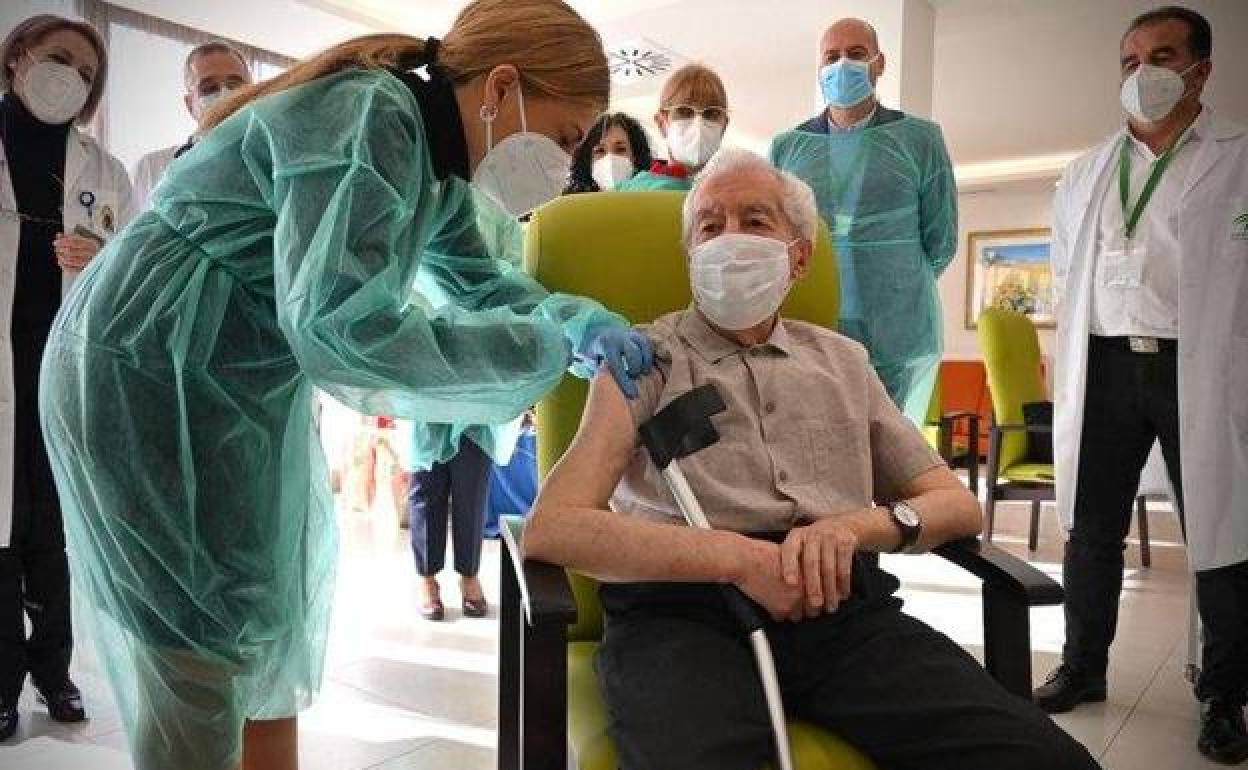 Una sanitaria vacuna a una persona mayor en una residencia. 