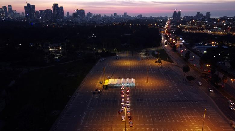 a gente espera en sus autos para hacerse la prueba del coronavirus en Tel Aviv, Israel.