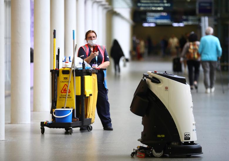 Un limpiador fotografía un robot de limpieza de atomizador de desinfección ultrasónico, conocido como Eco Bot 50, mientras limpia la estación internacional de St Pancras en medio del brote de coronavirus en Londres.