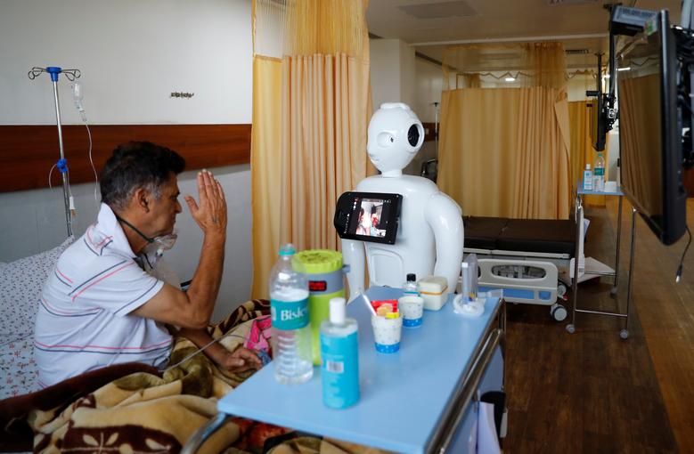 Un paciente que padece el coronavirus habla con sus familiares utilizando un robot llamado 'Mitra' en la Unidad de Cuidados Intensivos (UCI) del Hospital de Super Especialidades Yatharth en Noida, en las afueras de Nueva Delhi.