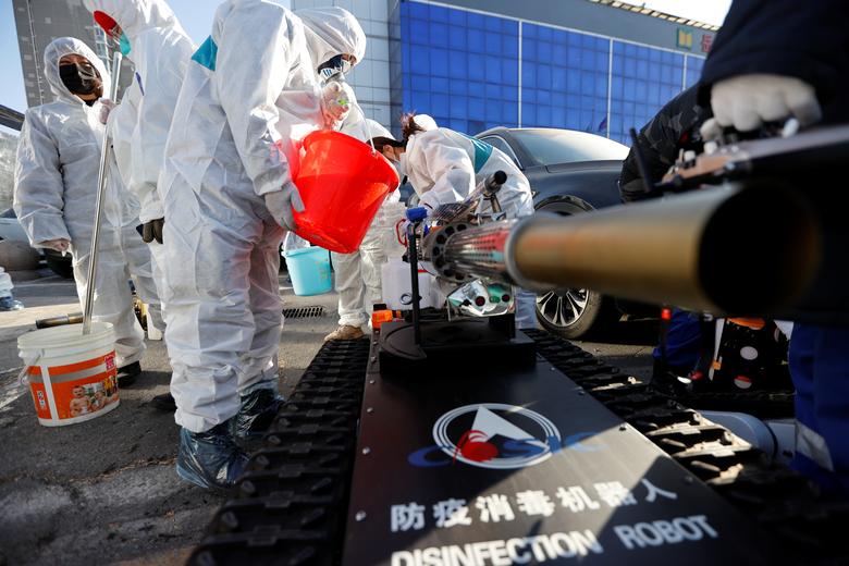 Un voluntario del equipo de Blue Sky Rescue llena un robot con desinfectante durante una operación para desinfectar el mercado mayorista de Yuegezhuang luego del brote de coronavirus en Beijing, China.