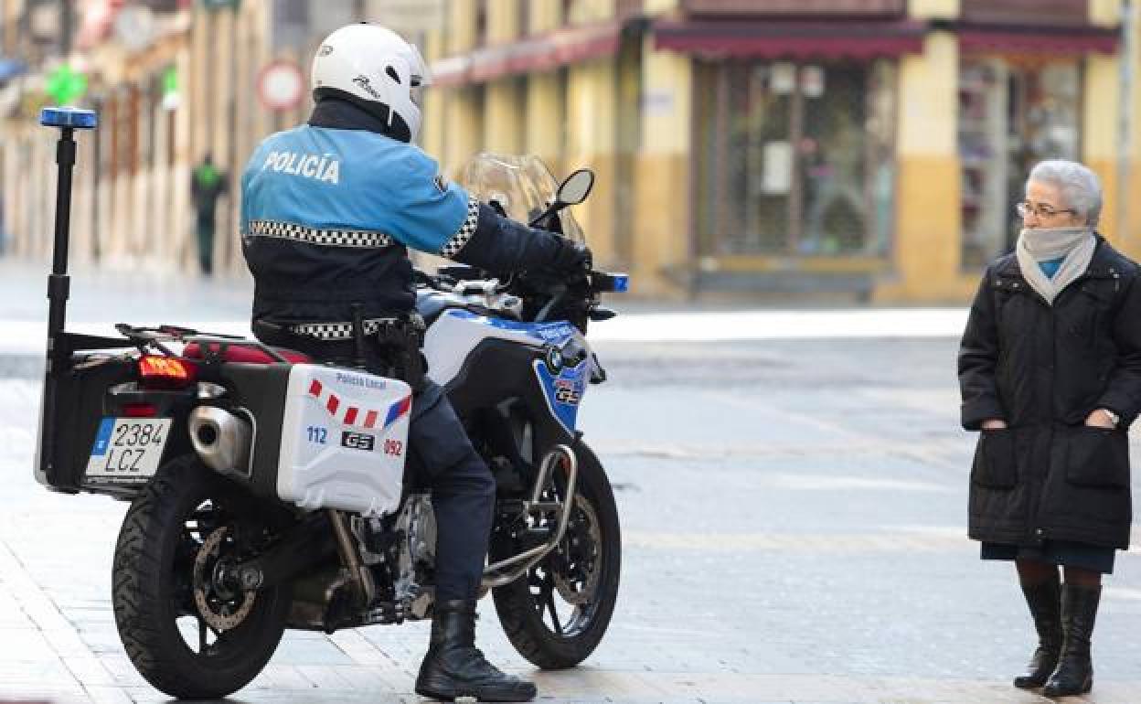 Un agente de la Policía Local de León atiende a una ciudadana. 