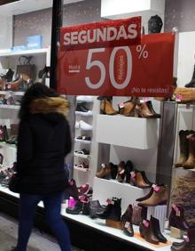 Imagen secundaria 2 - Los leoneses pasan frente a los escaparates del centro de León con las 'segundas rebajas'.