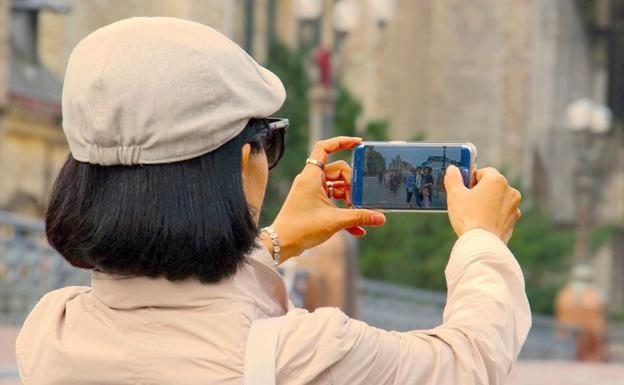 Una turista saca una foto con su móvil. 