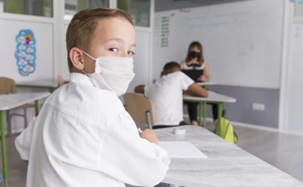 Un niño atiende en clase. 