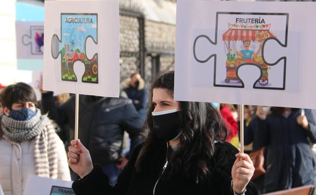 Una joven sostiene dos pancartas durante la manifestación de los autónomos.