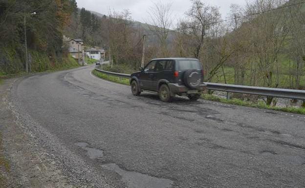 En El Llano, en Cargas de Narcea, los baches dejan ver las capas de asfalto que han ido parcheando la calzada de la AS-15 asturiana. 