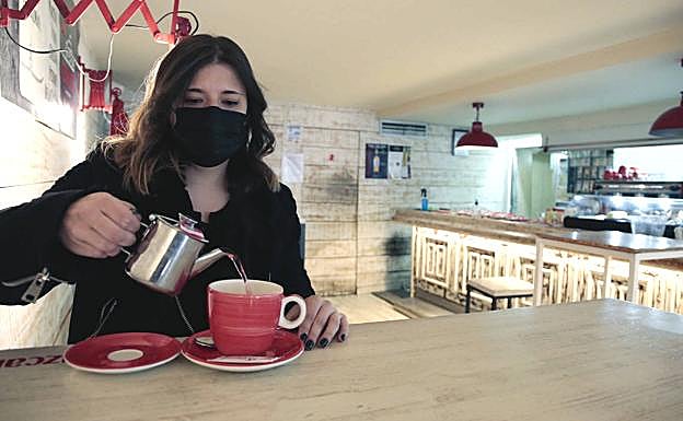 Galería. Una mujer toma un té en el interio de una bar.