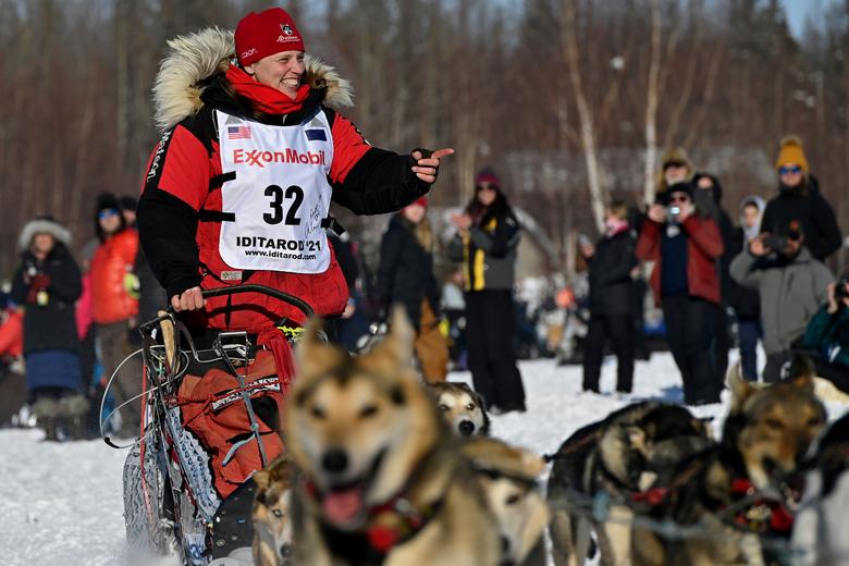 Aliy Zirkle, de Two Rivers, saluda a los fanáticos cuando pasa por el área de inicio de la carrera de perros de trineo.