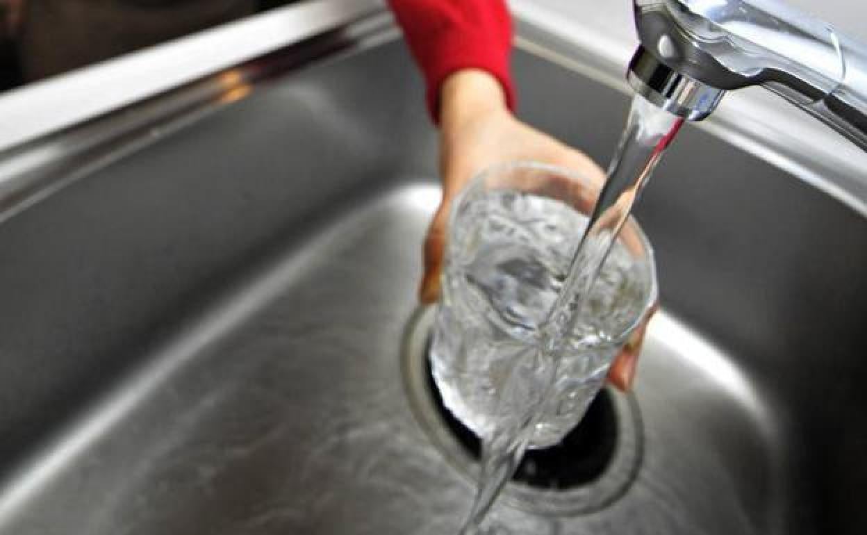 Imagen de archivo de una persona llenando un vaso de agua.