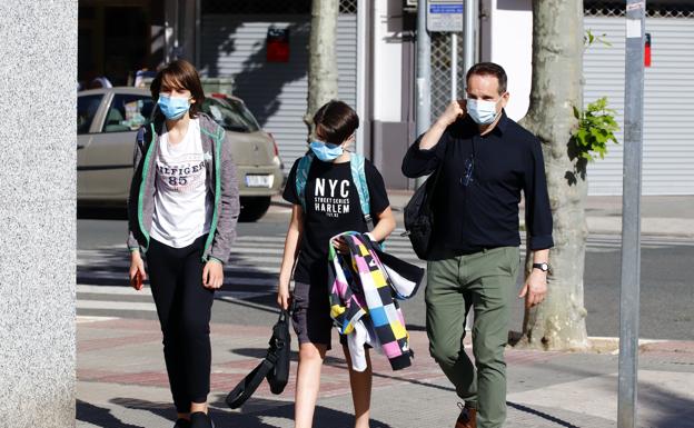 Una familia pasea con la mascarilla puesta. 