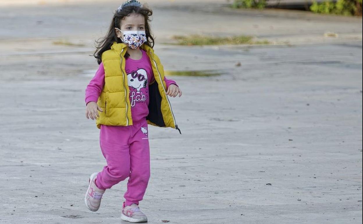 Una alumna camina hacia la entrada de su colegio.