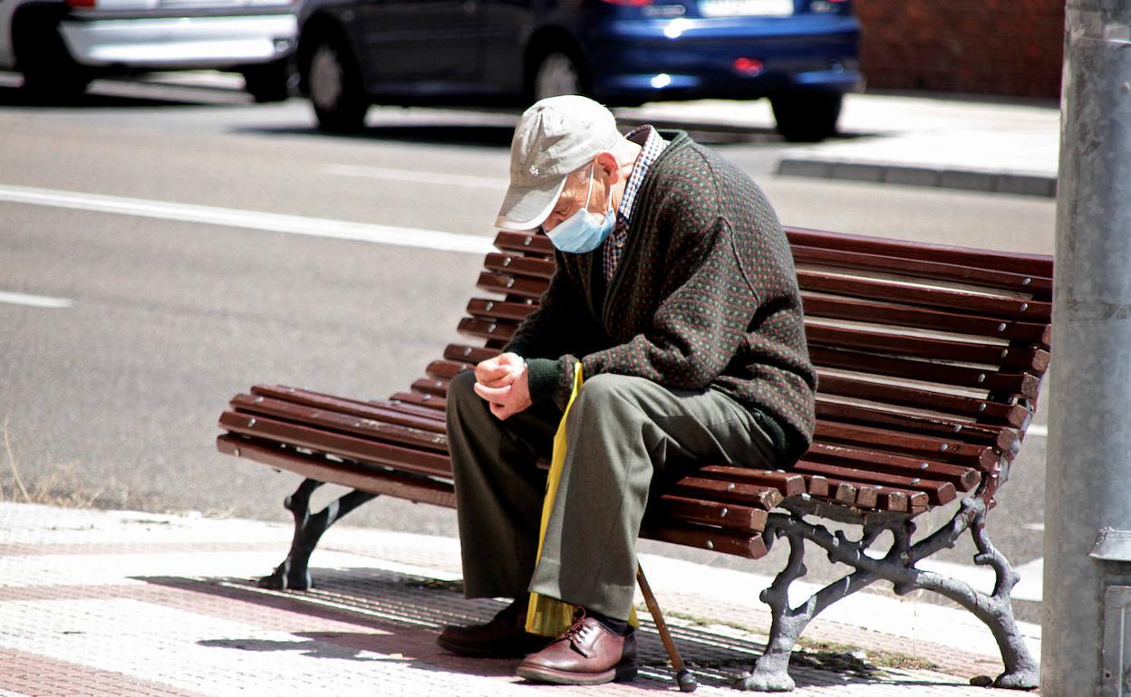 Un señor descansa en un banco de la capital leonesa. 