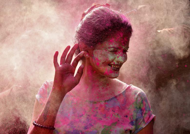 Una mujer reacciona cuando se le arroja polvo de color durante las celebraciones de Holi en Chennai, India.