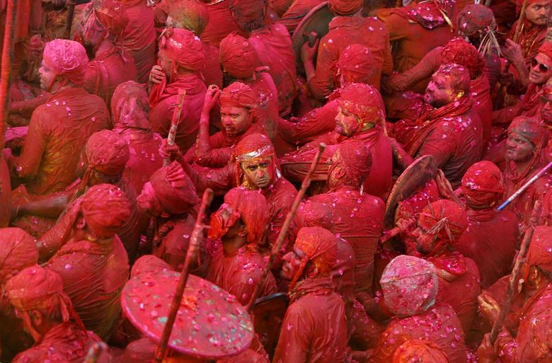 Hombres pintados de colores participan en las celebraciones de Lathmar Holi en la ciudad de Nandgaon, en el estado norteño de Uttar Pradesh, India.