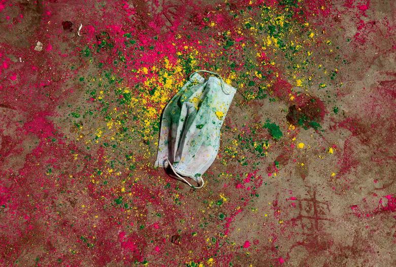 Una mascarilla yace en una carretera cubierta de polvo durante las celebraciones de Holi en Chennai, India