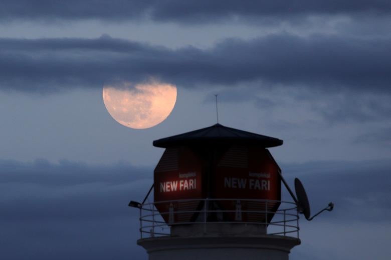 Se muestra una superluna rosa cerca de un faro en Tirana, Albania.