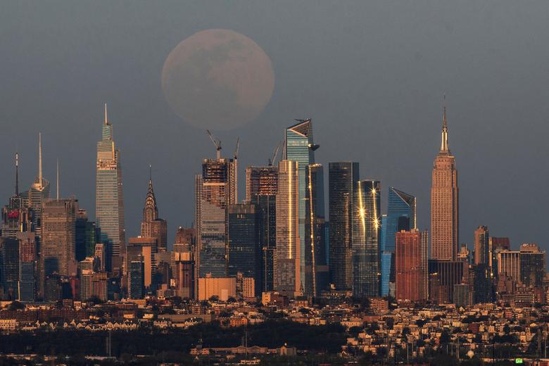 La luna llena, conocida como "Super Pink Moon", se eleva sobre el horizonte de Nueva York y el Empire State Building, visto desde West Orange, en Nueva Jersey.