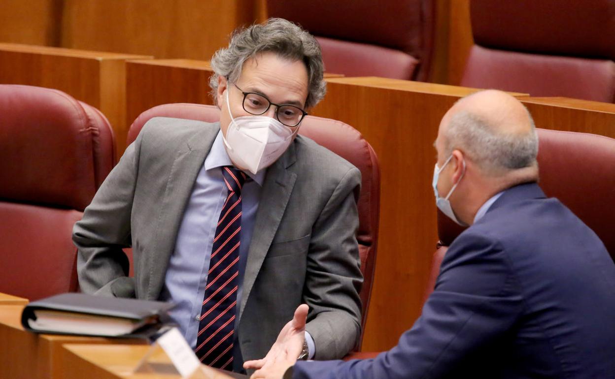 El portavoz del Grupo Ciudadanos, David Castaño (D), conversa con el procurador Miguel Ángel González (I) durante el Pleno de las Cortes