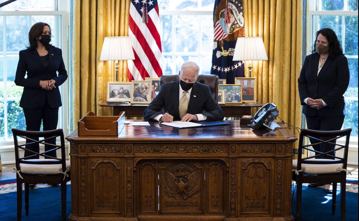 Biden firma en el Despacho Oval la extensión del programa de rescate acompañado de Kamala Harris e Isabel Guzmán, administradora de la Agencia de Pequeños Negocios.