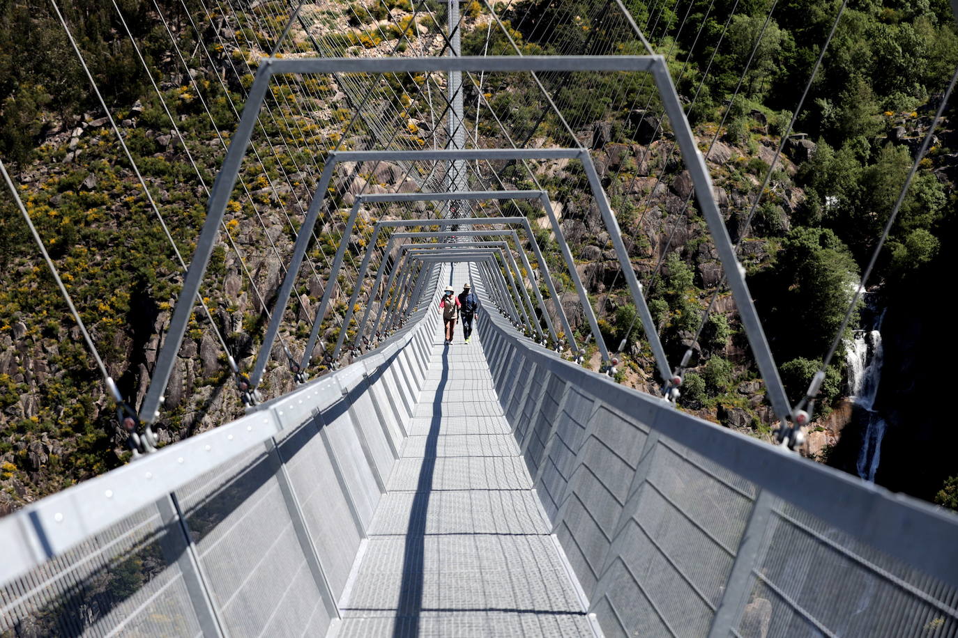 Portugal inauguró este jueves 29 de abril el puente peatonal suspendido más largo del mundo, a 175 metros sobre el río Paiva, en el norte, y que con sus 516 metros supera el récord establecido en 2017 por la pasarela Charles Kuonen de los Alpes suizos. El puente atraviesa un barranco granítico del municipio de Arouca y está formado por 127 planchas de rejilla con barandillas metálicas de 1,20 metros de ancho, sujetas por cables de acero a unos pilares en forma de 'V' situados a cada extremo.