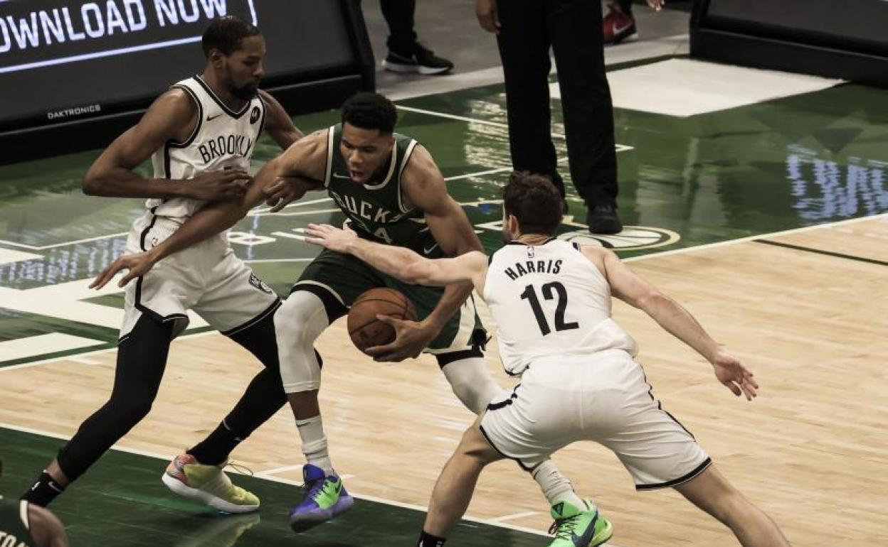 Giannis Antetokounmpo, rodeado por dos jugadores de los Nets. 