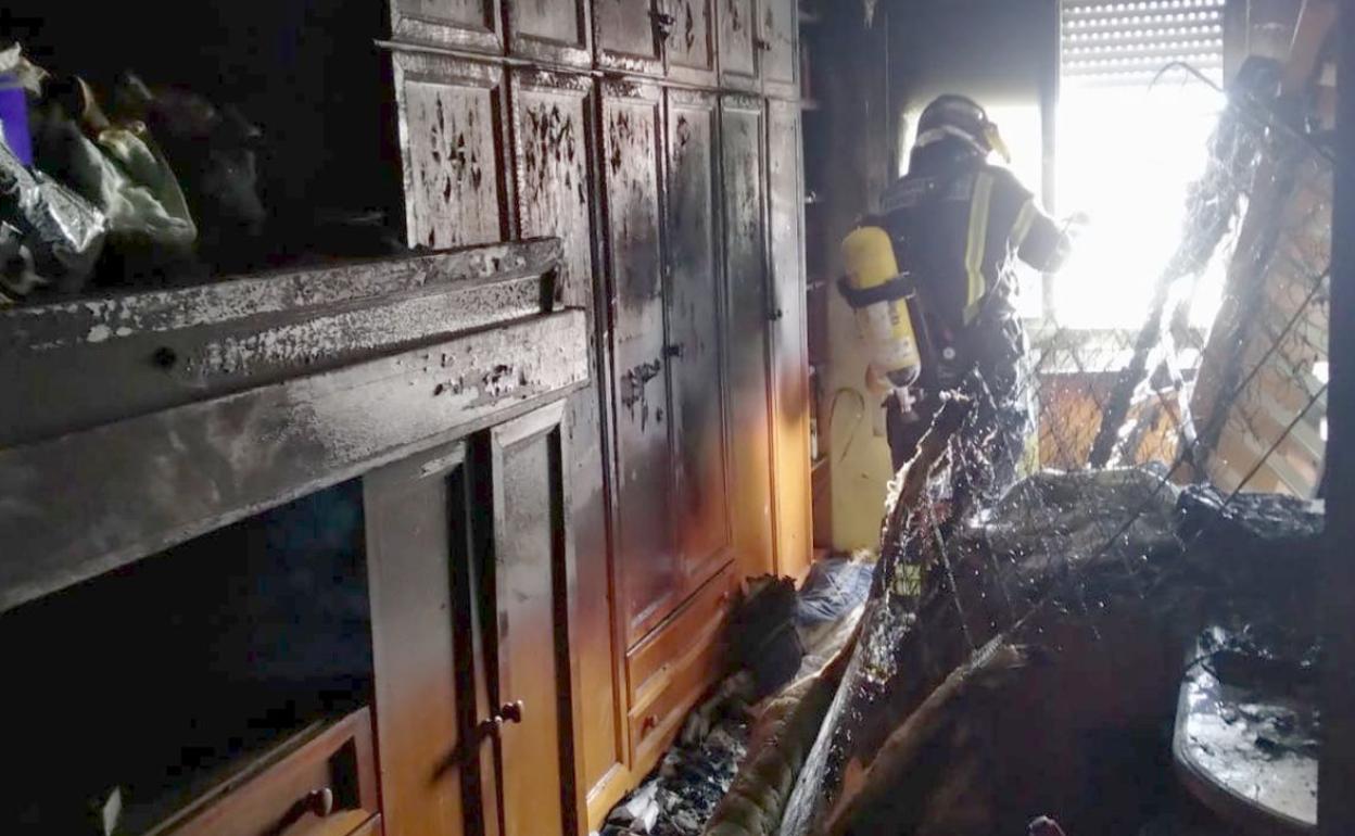 Un fuego calcina una habitación y se extingue por falta de oxigeno provocando daños en toda la vivienda en Ponferrada
