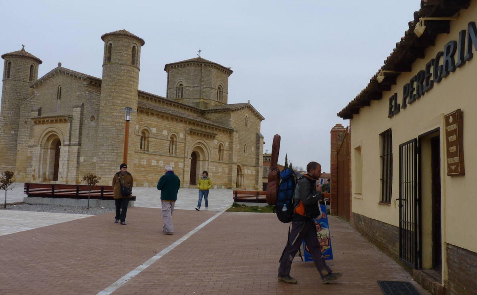 Un peregrino pasea por delante de la iglesia románica de San Martín de Frómista.